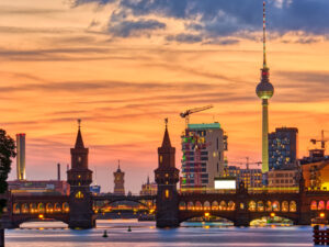 Oberbaumbrücke mit Fernsehturm bei Sonnenuntergang an der Spree – private Stadtrundfahrt Berlin mit Bus, Van oder ÖPNV und Guide